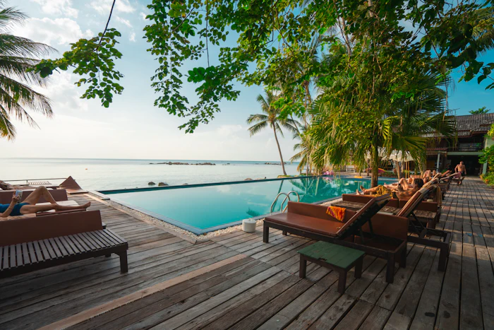 Illustrative photo: a shaded pool deck overlooking the sea